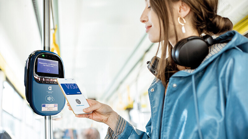 woman using mobile to pay for tram fair